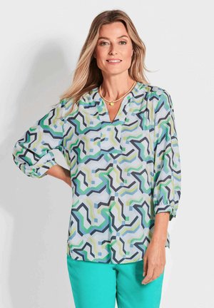 Lightweight, patterned blouse featuring a geometric design in shades of blue, green, and black, with a V-neck and three-quarter sleeves.