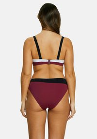 Ensemble de bikini comprenant un bralette bordeaux avec des bretelles noires et un bas assorti bordeaux. Texture lisse, détail de matériel ajustable sur les bretelles.