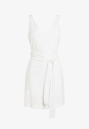 Valkoinen hihaton V-kaula-aukollinen haalari, jossa on sidottava vyö ja rei'itetyt kuviot helman läheisyydessä.