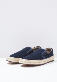 Marineblå mocka slip-on skor med elastisk sida, väven jute-sula och rund tådesign, med en robust, texturerad finish.