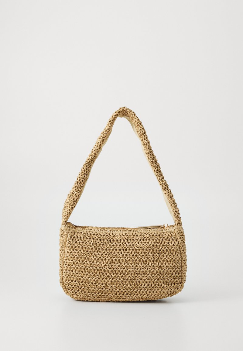 Sac à main en paille tissée avec une forme arrondie et structurée. Il possède une bandoulière courbée, une couleur beige clair et une fermeture éclair.