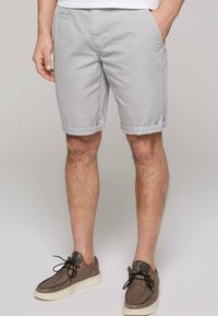 Lichtgrijze shorts in een katoenmix, met een comfortabele pasvorm, zijzakken en omgeslagen zoom. Gemaakt in combinatie met donkere casual schoenen.