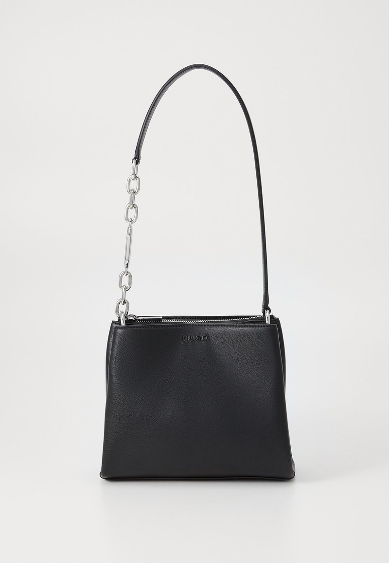 Czarna skórzana torebka o strukturalnym kształcie, wyposażona w srebrny łańcuszek, z góry zamykaną na zamek, oraz wytłoczone logo marki z przodu.