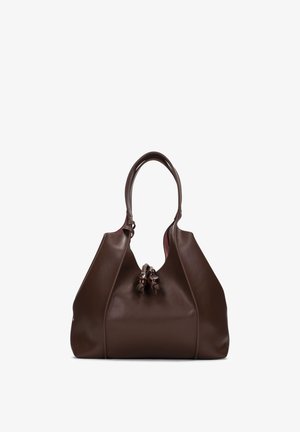 Sac à main en cuir marron avec poignées arrondies et nœuds décoratifs à l'avant, debout contre un fond blanc.