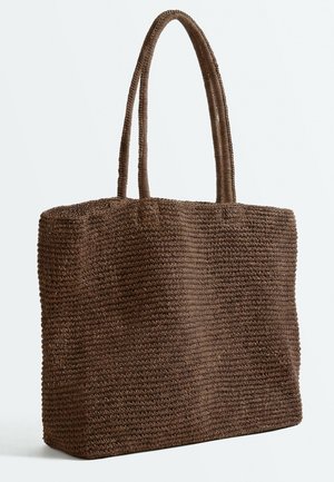 Sac cabas rectangulaire tissé marron avec deux longues anses, fabriqué en matériau en fibres naturelles texturées, posé sur un fond uni.