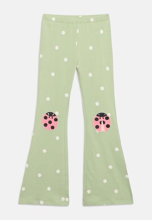Pantalones verde claro para niños pequeños con lunares blancos y parches de mariquitas rosas en las rodillas, piernas acampanadas, cintura elástica.