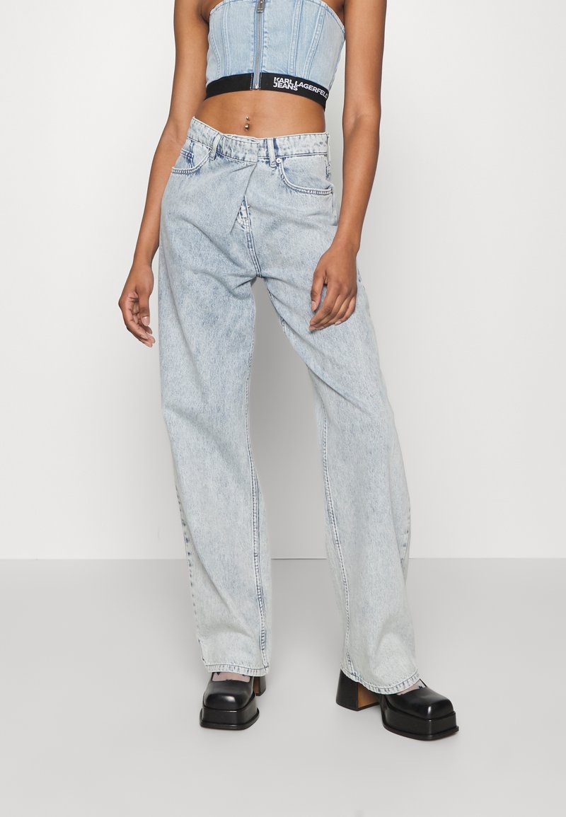 Ljust tvättade denimjeans med avslappnad passform, hög midja och framfickor, kombinerat med kraftiga svarta plattformsskor.