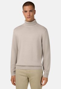 Šviesiai smėlinės spalvos megztinis su aukštu raugintų apykaklės kraštu ir raugintomis rankogaliais bei apačia. Reguliaraus silueto, su tekstūruotu paviršiumi.