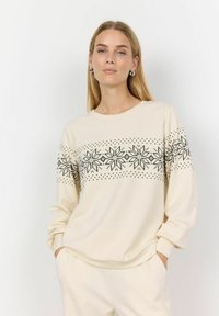 Crème-kleurige sweatshirt met een zwart geometrisch sneeuwvlokkenpatroon op de borst. Lange mouwen met een relaxte fit en een ronde halslijn.