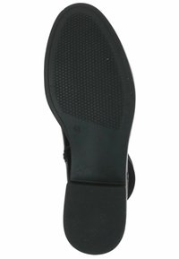 Black rubber shoe sole with a textured, patterned surface and rounded heel. Size notation “4½” visible on the side.