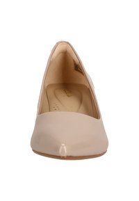 Beige patent leather high-heeled pump with a pointed toe and smooth texture. Interior features minimal cushioning and embossed brand logo.