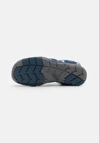 Sneaker with a textured gray rubber outsole and blue upper. The outsole features deep treads for grip and stability.