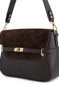 Brun læder- og ruskindstaske med klaplukning, fremhævet af en lås og beslag i guldtoner. Justerbar rem. Teksturerede overflader.