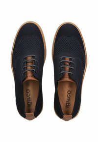 Scarpe lavorate a maglia blu navy con texture traspirante, dettagli in pelle marrone e lacci rotondi. Presentano una suola in gomma con un bordo a contrasto.