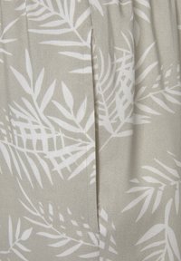 Jasnoszara tkanina z białymi wzorami liści, charakteryzująca się gładką teksturą i subtelnym połyskiem. Wzór zawiera pionowe zakładki po jednej stronie.