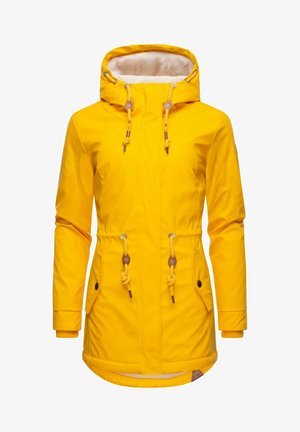 Keltainen vedenpitävä takki, jossa on fleecevuorattu huppu, kiristyskuminauhat, kaksi etutaskua ja elastiset hihansuut. Sujuva pinta ja keskipitkä malli.