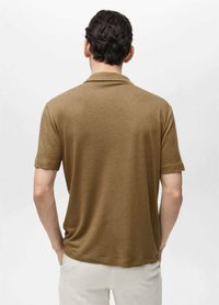 Polo a maniche corte color verde oliva, con colletto e vestibilità rilassata, realizzato in tessuto a maglia dal tocco morbido.