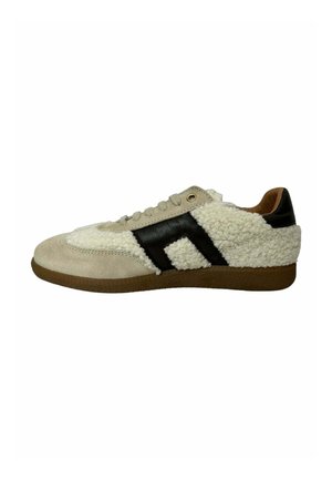 Zapatilla con parte superior de gamuza beige y suave blanca, que presenta una franja de cuero negro y una suela de goma marrón. Diseño casual con cierre de cordones.