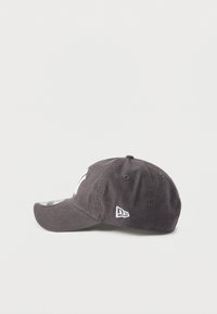 Grå bomulds-baseballkasket med buet skygge, med hvidt broderet logo foran og et lille brandmærke i siden.