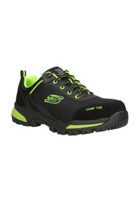 Scarpe sportive nere e verde neon con punta composita, tessuto testurizzato, suola in gomma e lacci rinforzati, progettate per durata e sicurezza.
