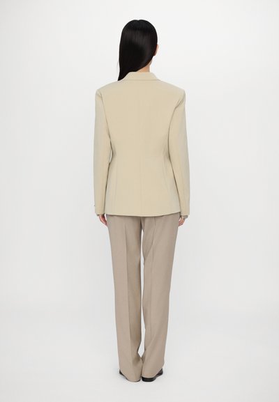 Beige tailored jacket with structured shoulders, paired with beige wide-leg trousers. Smooth fabric with a clean design, no embellishments.