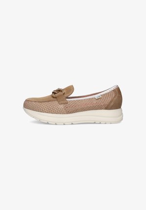 Zapato beige tipo slip-on con lados de malla texturizada, puntera y talón de ante, cadena decorativa en la parte superior y suela gruesa blanca.