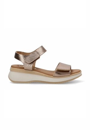 Sandal metálico en color oro rosa con dos correas ajustables, plantilla acolchada y suela blanca, ligeramente elevada, con textura antideslizante.