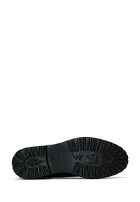 Suela de zapato de goma negra con un patrón de banda de rodadura profundo, que presenta un diseño de logotipo elevado y bordes estriados para mejorar la tracción y la durabilidad.