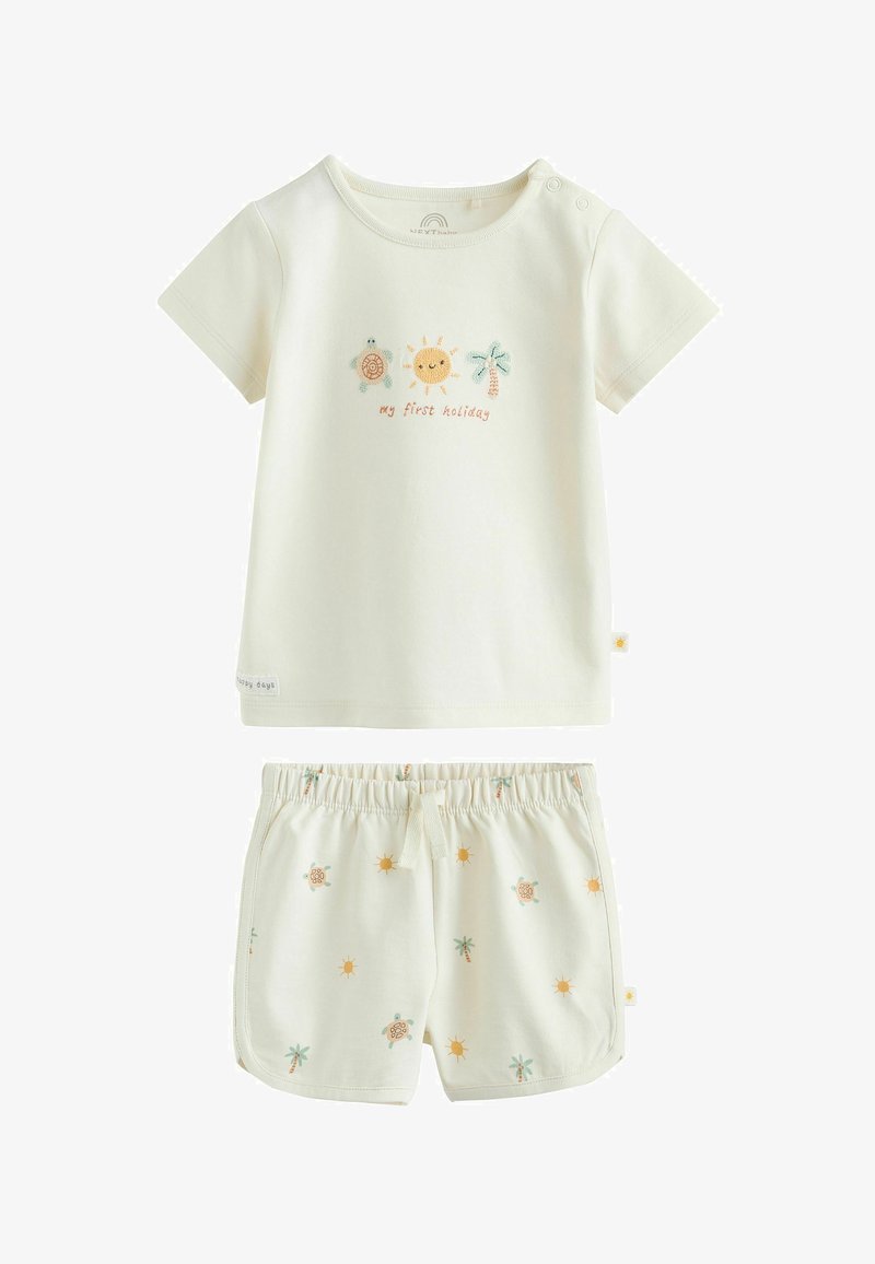 Tenue crème pour tout-petit avec chemise à manches courtes affichant un soleil, une tortue, un palmier et le texte « mes premières vacances », associée à un short imprimé assorti.