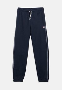 Φόρμες σε ναυτικό μπλε χρώμα από μαλακό ύφασμα, με λευκό κορδόνι, ελαστικές μανσέτες και λευκές πλευρικές ρίγες με λογότυπο στο αριστερό μηρό.