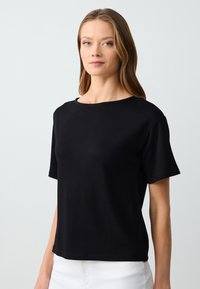 Zwarte kortemouw katoen T-shirt met een ronde halslijn en een losse pasvorm. De stof lijkt glad, met nette stiksels en geen zichtbare patronen.