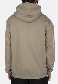 Hooded sweatshirt in light beige, made of soft fabric, featuring a kangaroo pocket, ribbed cuffs, and hem. Back view shows a seamless design.