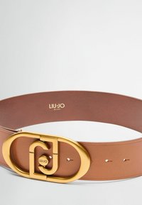 Brun læderbælte med en stor guldmetals oval spænde med logo detalje, glat tekstur og flere justeringshuller.