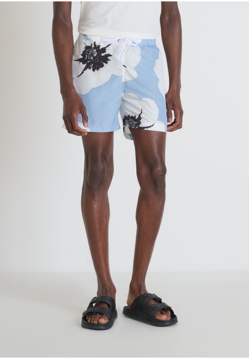 Costumi da bagno floreali blu e bianchi con un motivo floreale nero, realizzati in tessuto leggero, dotati di vita elastica e coulisse.