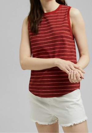 Rød ærmeløs top med vandrette striber i hvid og lys rød, som har en afslappet pasform og en rundt halsudskæring; båret med lyse slidte shorts.