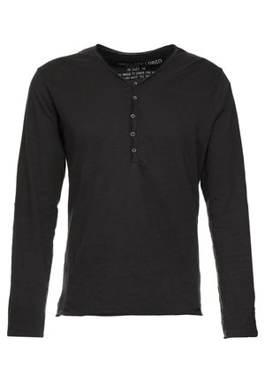 Camisa de manga larga negra hecha de una tela suave con un cuello henley, una tapeta de tres botones y un corte relajado.