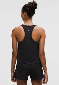 Top sportivo nero senza maniche con design a schiena a tapiro, caratterizzato da pannelli in rete traspirante. Abbinato a pantaloni corti neri testurizzati, entrambi realizzati in materiale leggero.