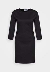 Musta mekko, jossa on pitkät hihat, pyöreä pääntie, istuva siluetti ja kaksi koristeellista nappia vyötäröllä. Sileä kangaspinta.