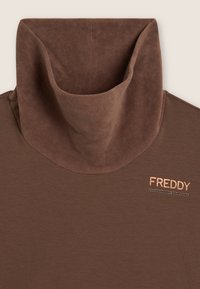 Maglia marrone a maniche lunghe con colletto alto e morbido. Presenta un logo "FREDDY" in oro rosa e una fila di borchie decorative sul davanti.