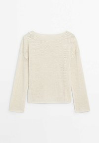 Lysebeige striktrøje med løs, åben vævning og lange ærmer. Kvadratisk halsudskæring og afslappet pasform med minimal detaljering.