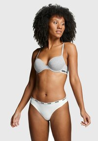 Grauer Sport-BH mit vorgeformten Cups und dünnen Trägern, kombiniert mit weißen Slips im Bikinistil, die ein schwarzes Puma-Logo am Bund haben.