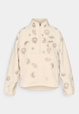 Pulover din fleece crem cu închidere cu fermoar pe jumătate, decorat cu broderie paisley și florală în nuanțe de bej, având un guler înalt și mâneci raglan.