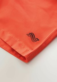 Orangefarbige Stoffshorts mit glatter Textur. Verfügt über ein schwarzes Logo-Detail am Saum und sichtbare Nähte entlang der Kanten.