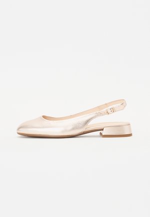 Metalen beige slingback platte schoen met een lage blokhak en een verstelbare zijriem met gesp, zijaanzicht.