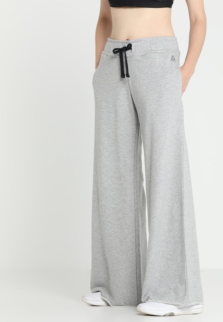 Ljust grå, vida sweatpants i mjukt tyg, med ett elastiskt midjeband med dragsko och subtila sömnadsdetaljer.