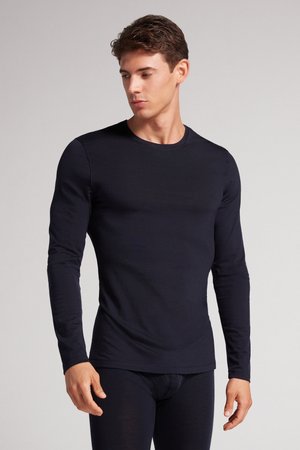 Langärmliges schwarzes Thermoshirt aus glattem Stoff, mit rundem Halsausschnitt und figurbetontem Schnitt, kombiniert mit passenden dunklen Hosen.