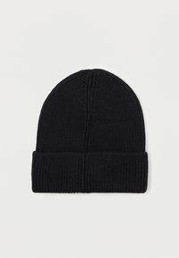 Berretto lavorato a maglia nero con una texture a coste e una fascia piegata. Presenta un design senza cuciture con cuciture verticali sulla parte superiore.