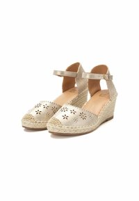 Espadrilles de cuña con parte superior de cuero dorado metálico, borde ondulado y patrón de flores troquelado. Plataforma de yute trenzado y correa para el tobillo.