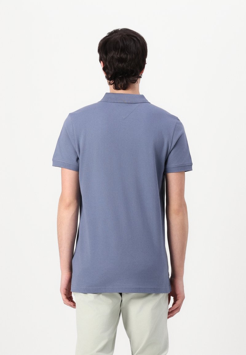 Polo à manches courtes en coton bleu doux, doté d'un col classique et d'un ourlet droit. Design minimaliste sans motifs ni accents visibles.