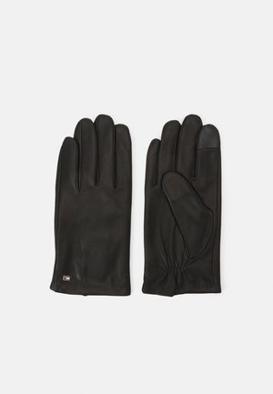 Zwarte leren handschoenen met vijf vingers, elastische pols en een textuurdetails op één vingertop voor extra grip. Bevat een klein logo-label op de pols.